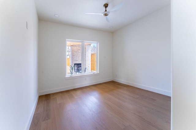 spare room with wood finished floors, baseboards, and ceiling fan