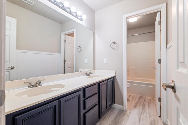 full bathroom with double vanity, visible vents, toilet, and a sink