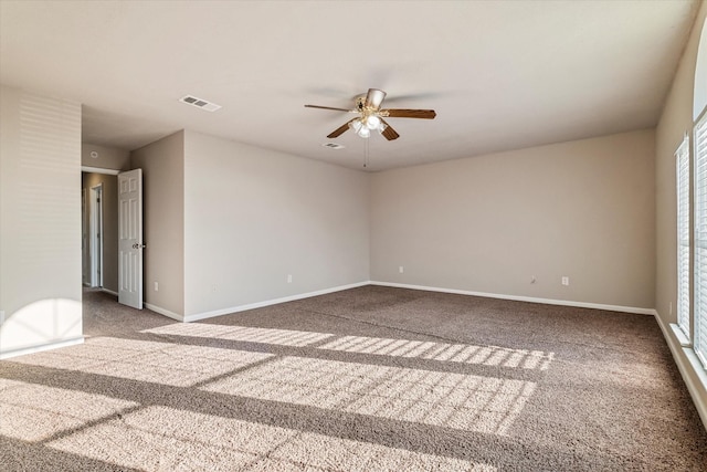 empty room with ceiling fan, carpet flooring, visible vents, and baseboards