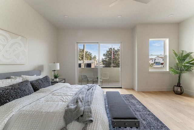 bedroom featuring baseboards, wood finished floors, and access to exterior