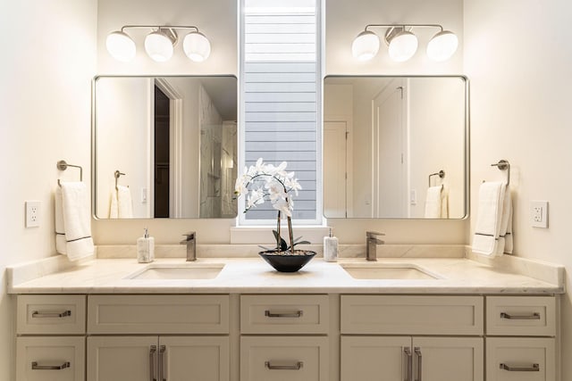 bathroom with double vanity, a shower, and a sink