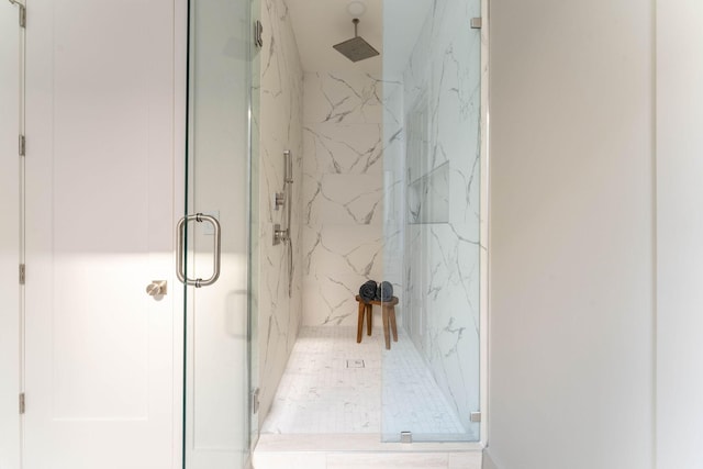 bathroom featuring a marble finish shower