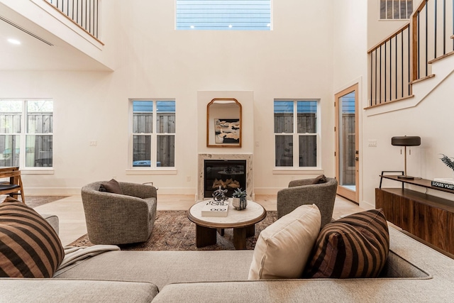 living area featuring visible vents, a fireplace, baseboards, and wood finished floors