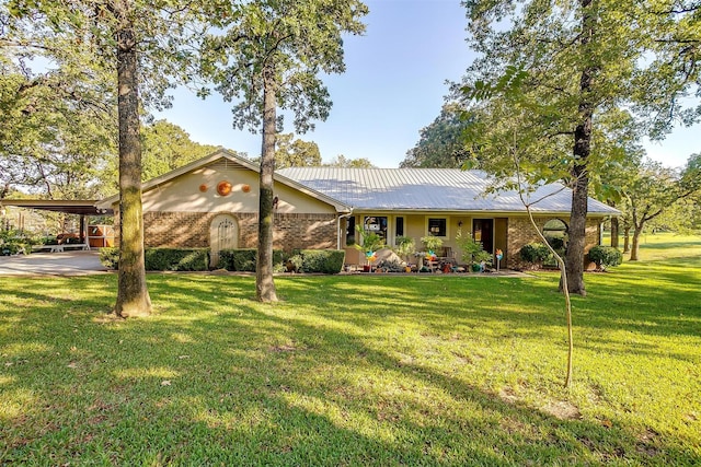 ranch-style home with metal roof, brick siding, a front yard, and an attached carport