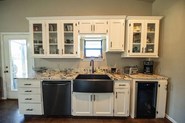 kitchen with beverage cooler, dishwashing machine, a sink, and white cabinetry