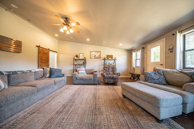 living area featuring a barn door, ceiling fan, a textured ceiling, and recessed lighting