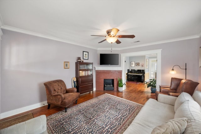 living room with visible vents, baseboards, a ceiling fan, ornamental molding, and wood finished floors