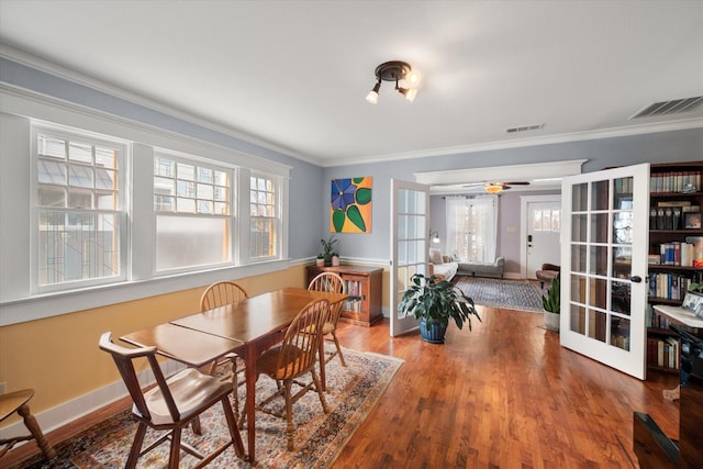 dining area featuring crown molding, visible vents, wood finished floors, and french doors