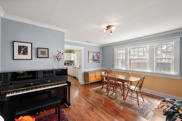 dining space with ornamental molding, dark wood-type flooring, and baseboards