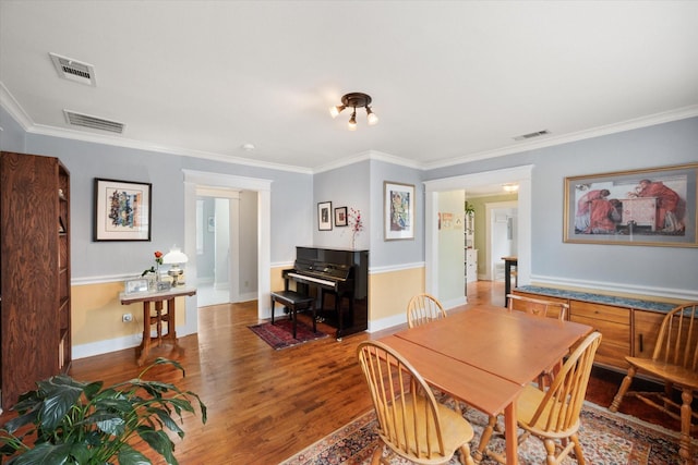 dining room featuring ornamental molding, wood finished floors, and visible vents