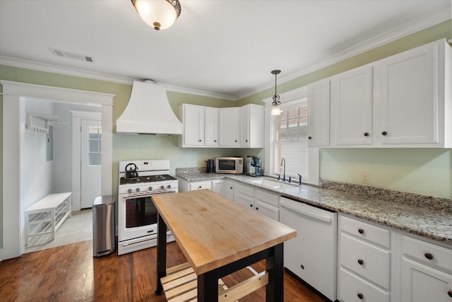 kitchen with white appliances, white cabinetry, a sink, and custom exhaust hood