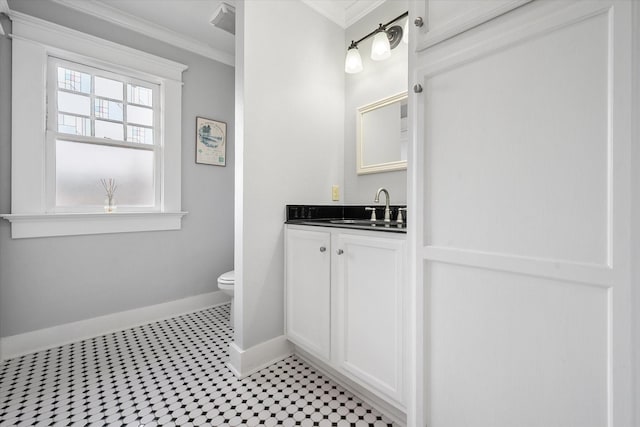 bathroom featuring toilet, baseboards, crown molding, and vanity