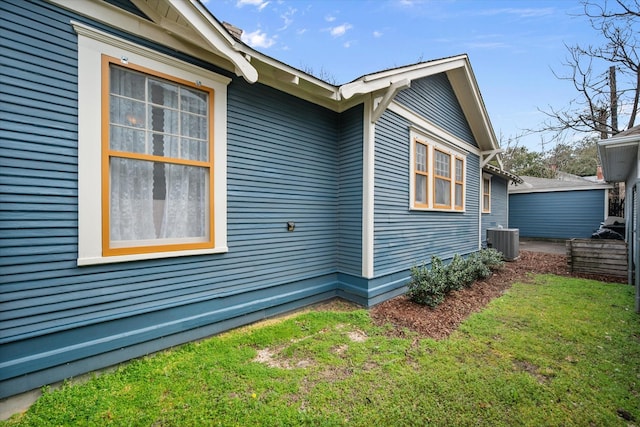 view of property exterior with a yard and central AC unit