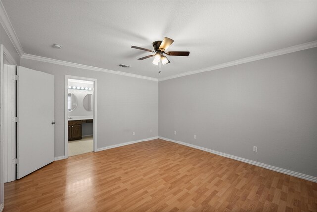 spare room with light wood-type flooring, crown molding, and baseboards