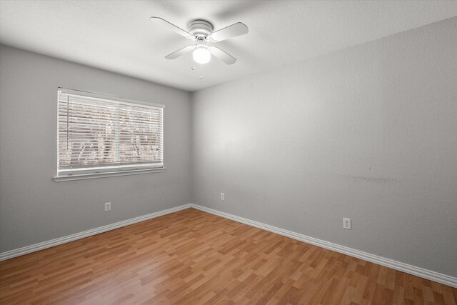 unfurnished room featuring light wood-style floors, baseboards, visible vents, and ceiling fan