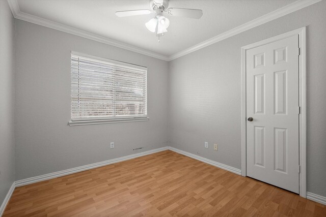 unfurnished room featuring light wood finished floors, visible vents, ornamental molding, a ceiling fan, and baseboards