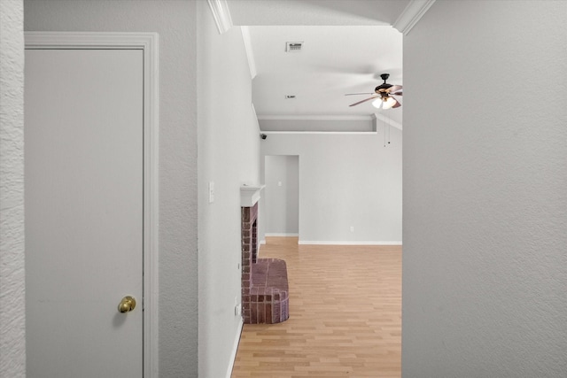 hallway with visible vents, crown molding, baseboards, and wood finished floors