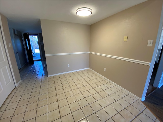 empty room featuring light tile patterned floors and baseboards