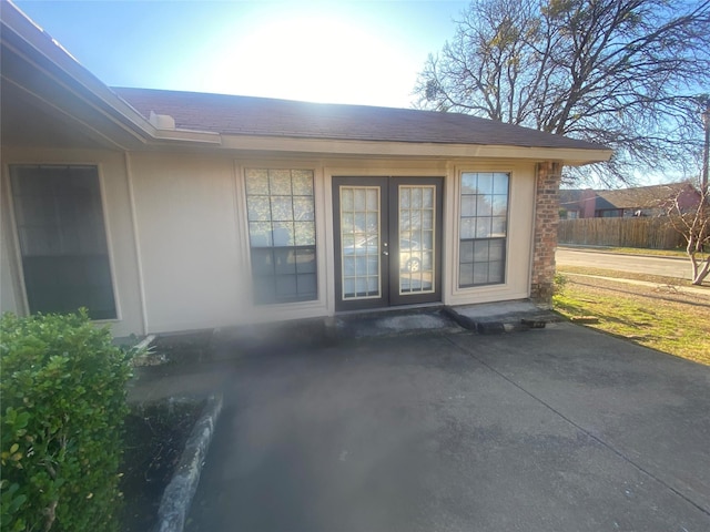 entrance to property featuring fence and stucco siding