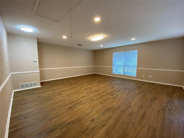 spare room with recessed lighting, wood finished floors, visible vents, and baseboards