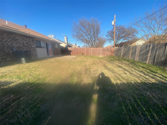 view of yard featuring fence and central air condition unit