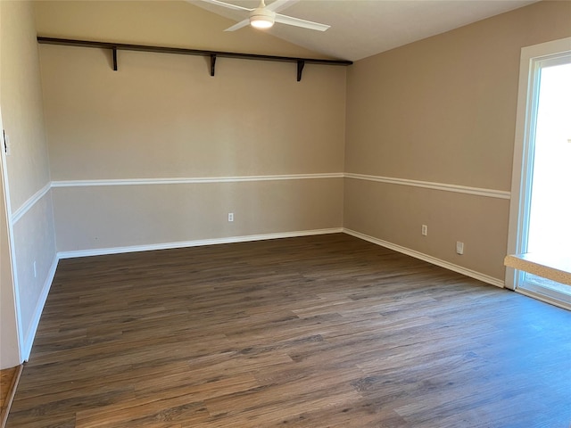unfurnished room featuring vaulted ceiling, a ceiling fan, dark wood-style flooring, and baseboards