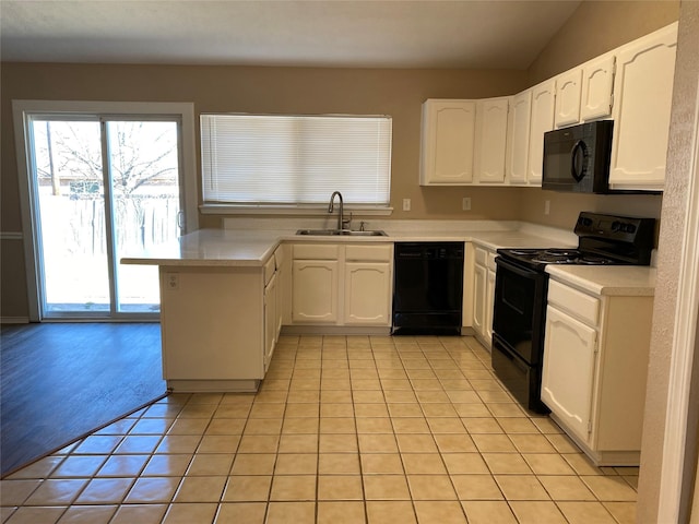 kitchen featuring a sink, black appliances, and white cabinetry
