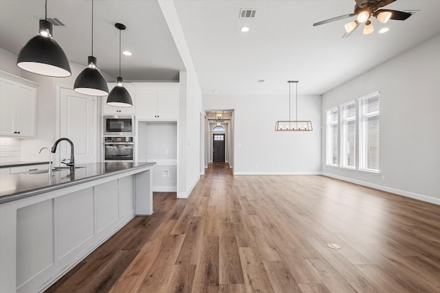 kitchen with a sink, stainless steel appliances, visible vents, and white cabinetry