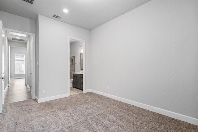 unfurnished bedroom featuring light carpet, visible vents, recessed lighting, and baseboards