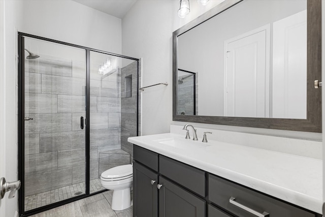 bathroom featuring a stall shower, toilet, and vanity