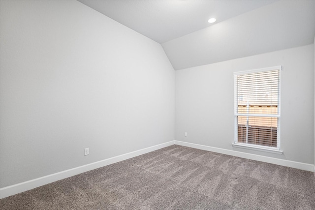 empty room featuring carpet flooring, recessed lighting, baseboards, and vaulted ceiling