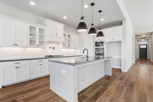 kitchen featuring white cabinets, wood finished floors, appliances with stainless steel finishes, and a sink