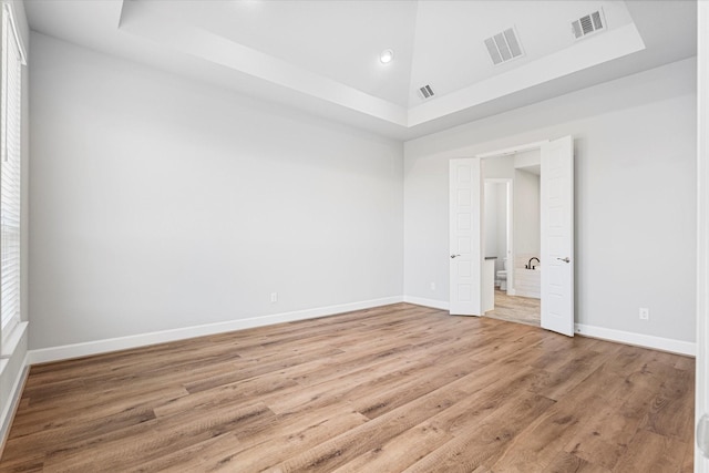 empty room featuring light wood-type flooring, baseboards, and visible vents