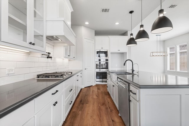 kitchen featuring visible vents, a sink, dark countertops, white cabinetry, and appliances with stainless steel finishes