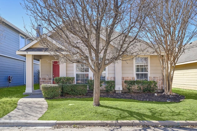 view of front of house featuring stone siding and a front yard