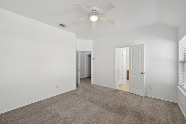 unfurnished bedroom with light carpet, baseboards, visible vents, a ceiling fan, and vaulted ceiling