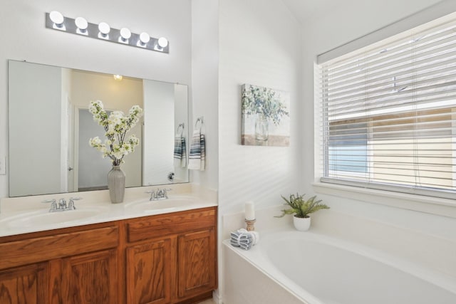 bathroom with a garden tub, plenty of natural light, and a sink