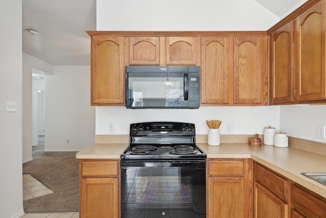 kitchen featuring black appliances, light countertops, and light colored carpet