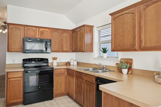 kitchen featuring brown cabinetry, lofted ceiling, light countertops, black appliances, and a sink