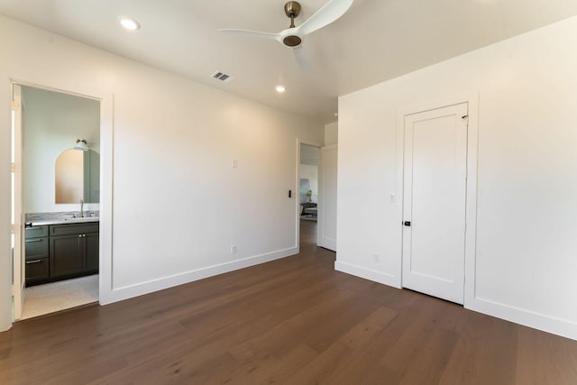 unfurnished bedroom with dark wood finished floors, recessed lighting, visible vents, a sink, and baseboards