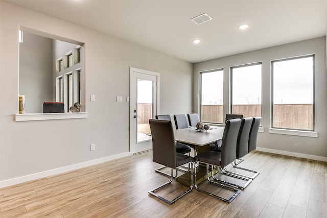 dining room featuring visible vents, baseboards, and wood finished floors