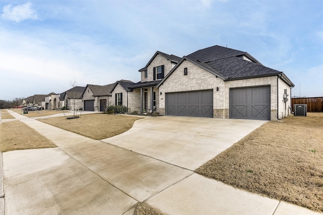 view of front facade featuring brick siding, central air condition unit, a shingled roof, concrete driveway, and a garage