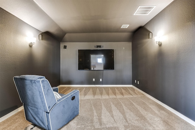 carpeted home theater with vaulted ceiling, visible vents, and baseboards