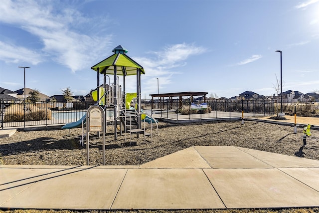 community playground with a residential view and fence