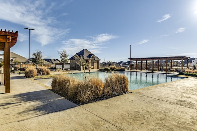 community pool with a patio area, fence, and a pergola