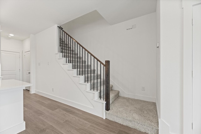 staircase with wood finished floors and baseboards