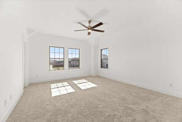 spare room with a ceiling fan, light carpet, and baseboards