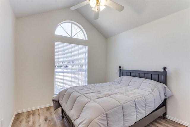 bedroom featuring ceiling fan, vaulted ceiling with beams, baseboards, and wood finished floors