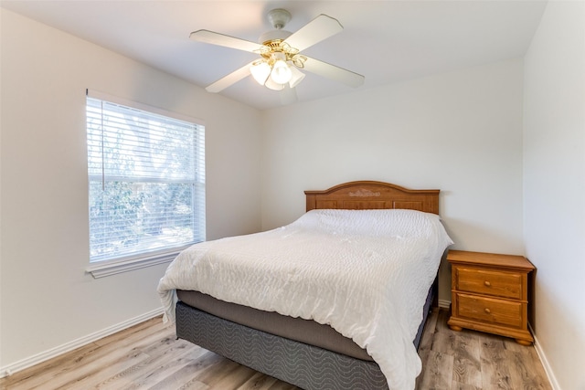 bedroom featuring a ceiling fan, baseboards, and light wood finished floors