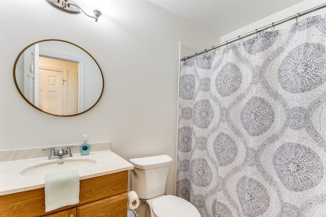 bathroom featuring toilet, a shower with curtain, and vanity